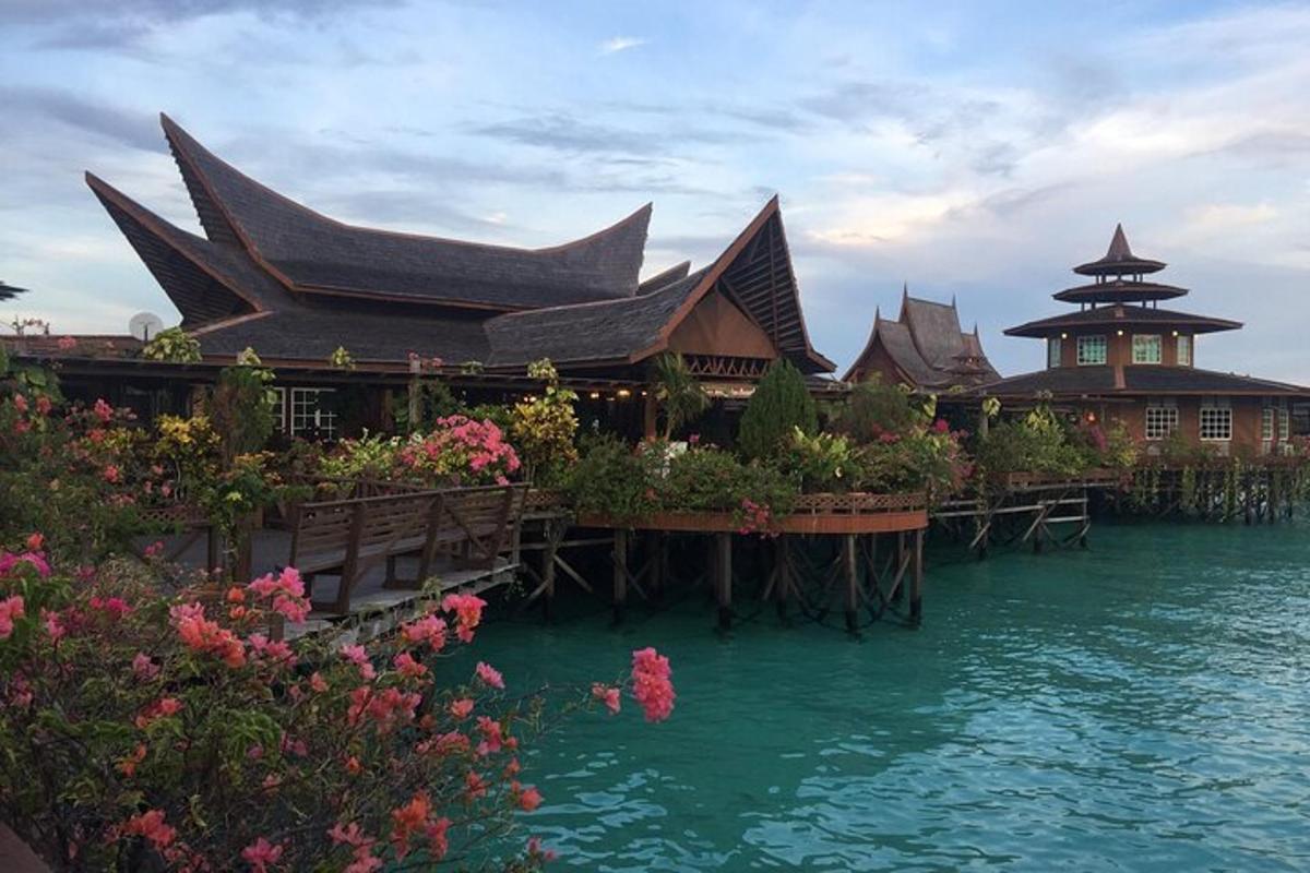 a building on the water with plants and flowers
