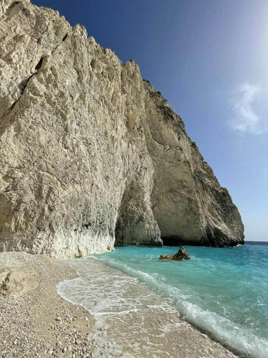 una spiaggia con acqua blu e una scogliera rocciosa