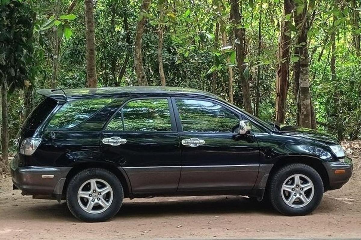 a black car parked in front of a forest