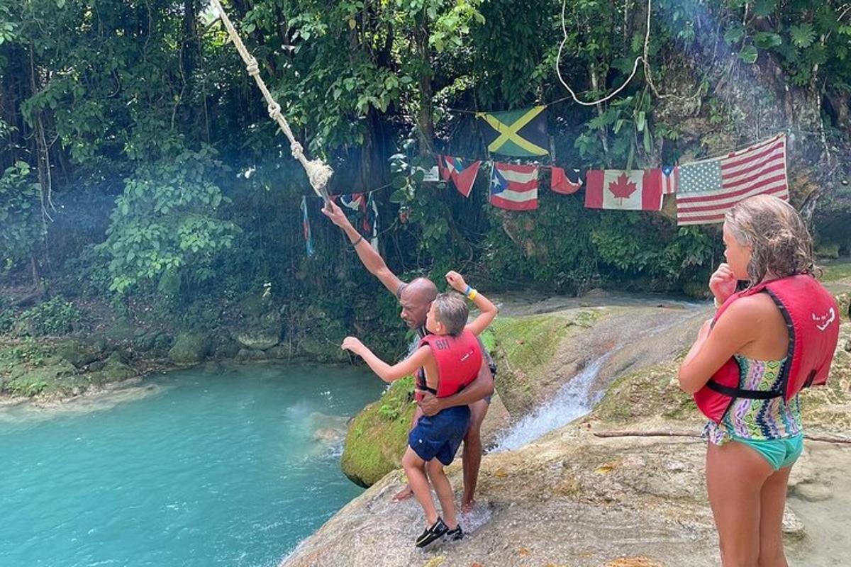 seorang lelaki memegang kanak-kanak di atas tali di atas sungai