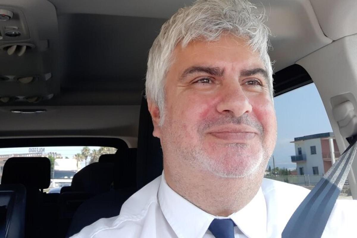 um homem de gravata sentado em um carro