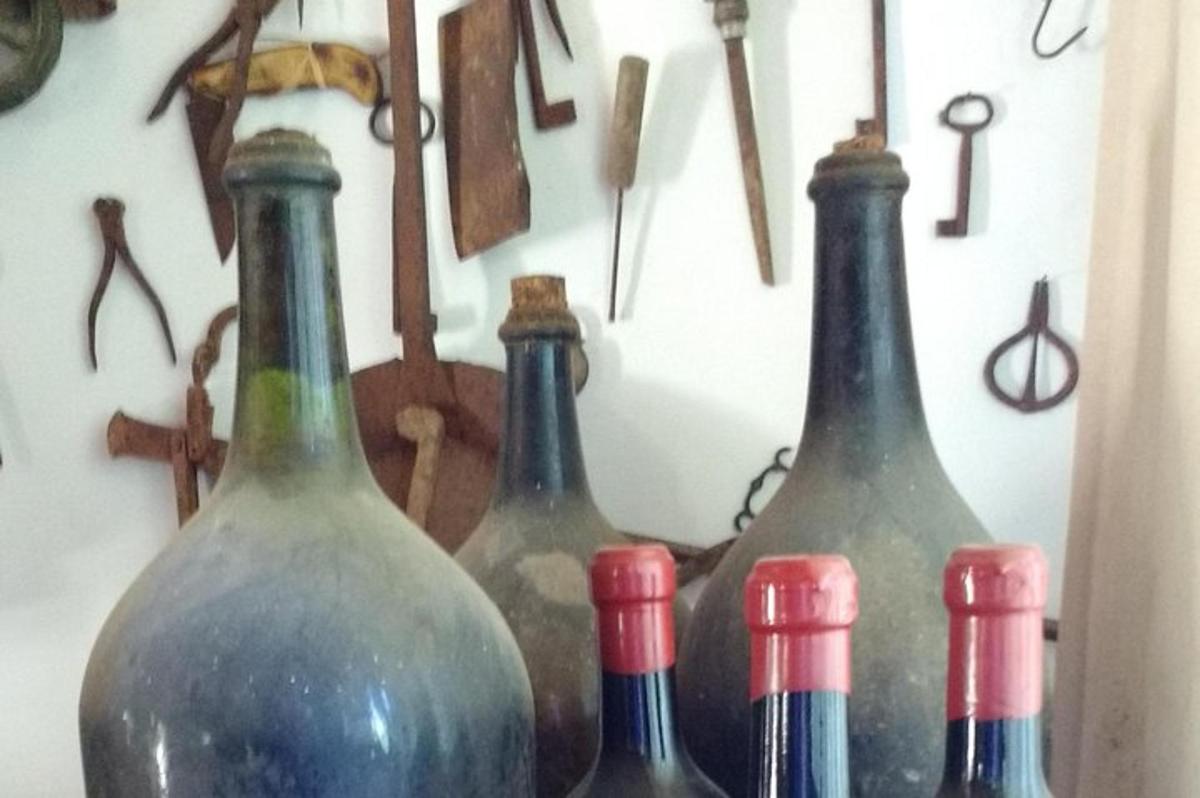 quattro bottiglie di vino allineate davanti a un orologio