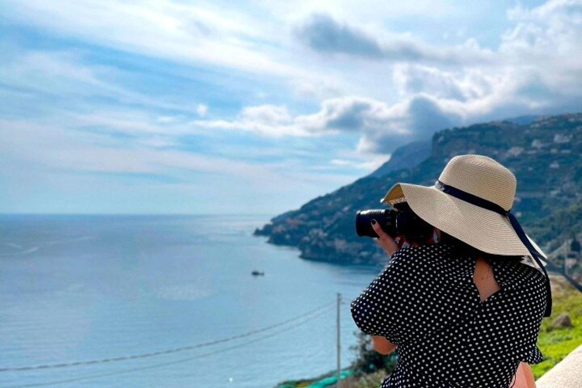 Μια γυναίκα φωτογραφίζει τον ωκεανό με μια φωτογραφική μηχανή