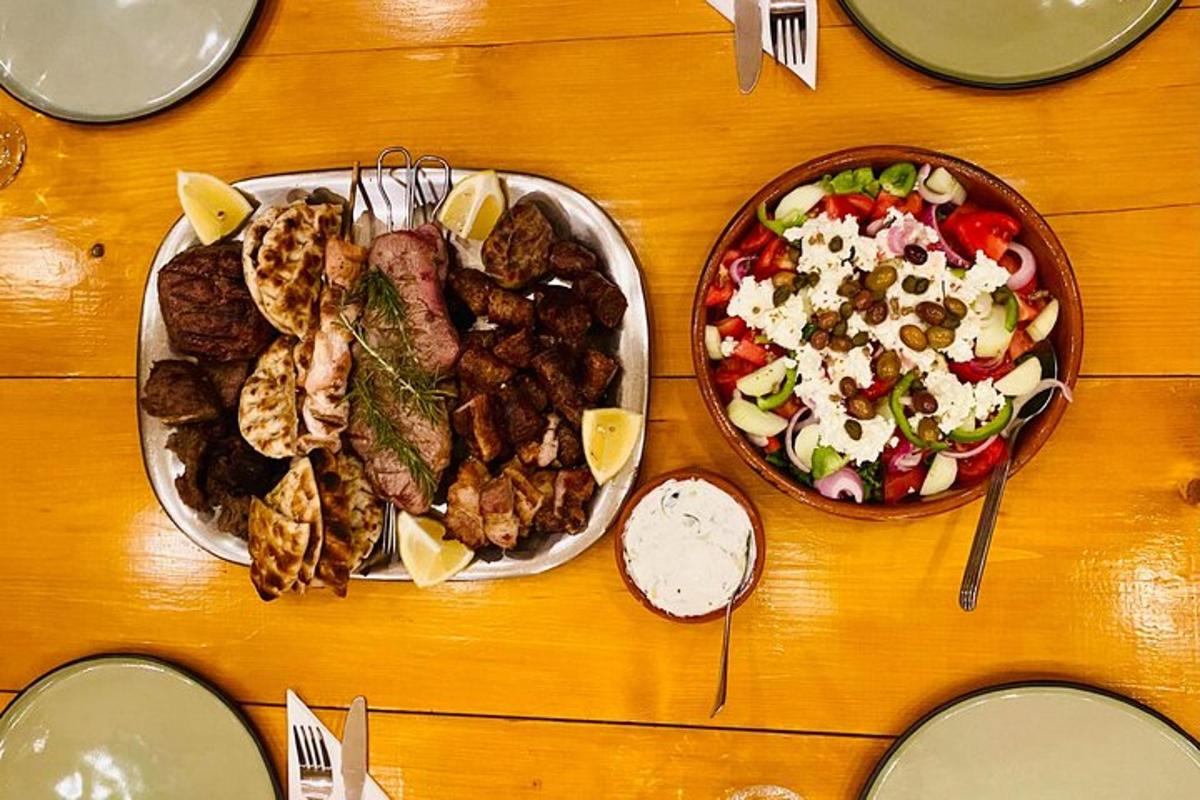 borð með tveimur diskum af mat og skál af salati