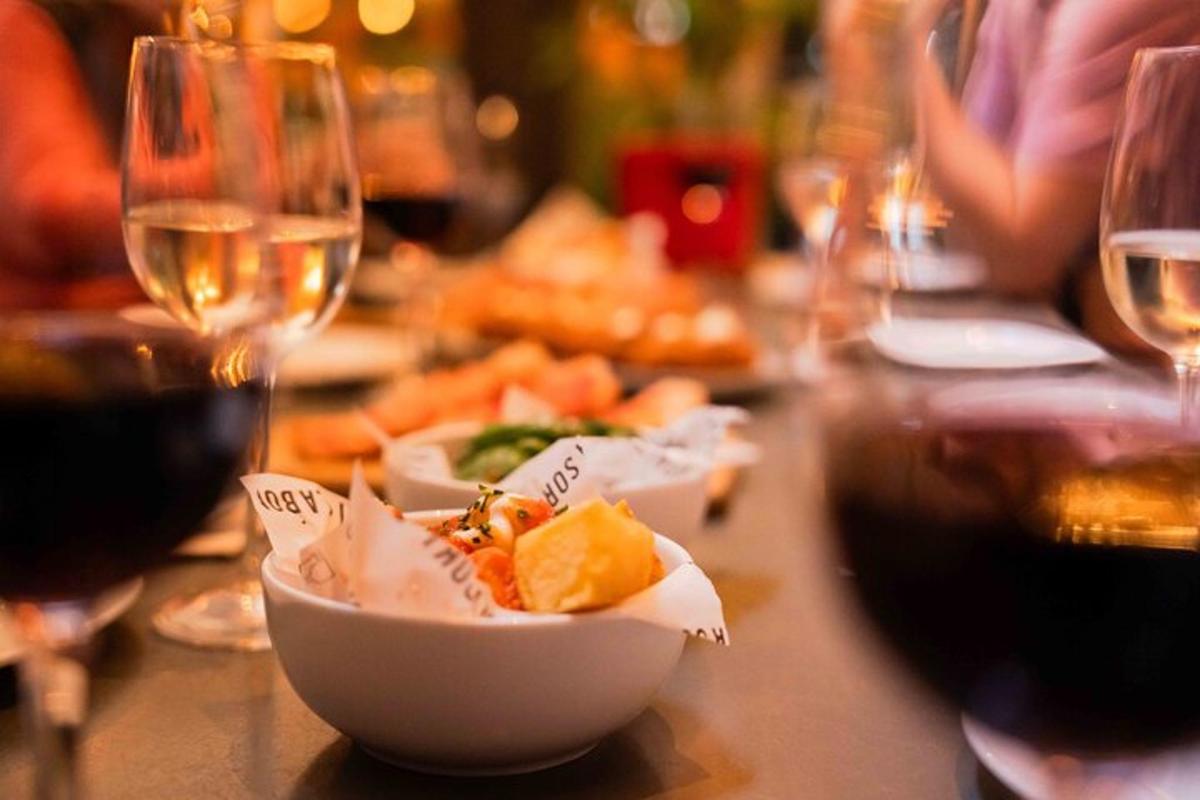 uma mesa com taças de vinho e uma tigela de comida