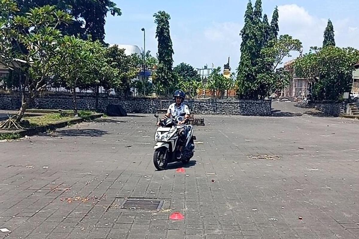 una persona che guida una motocicletta in un parcheggio