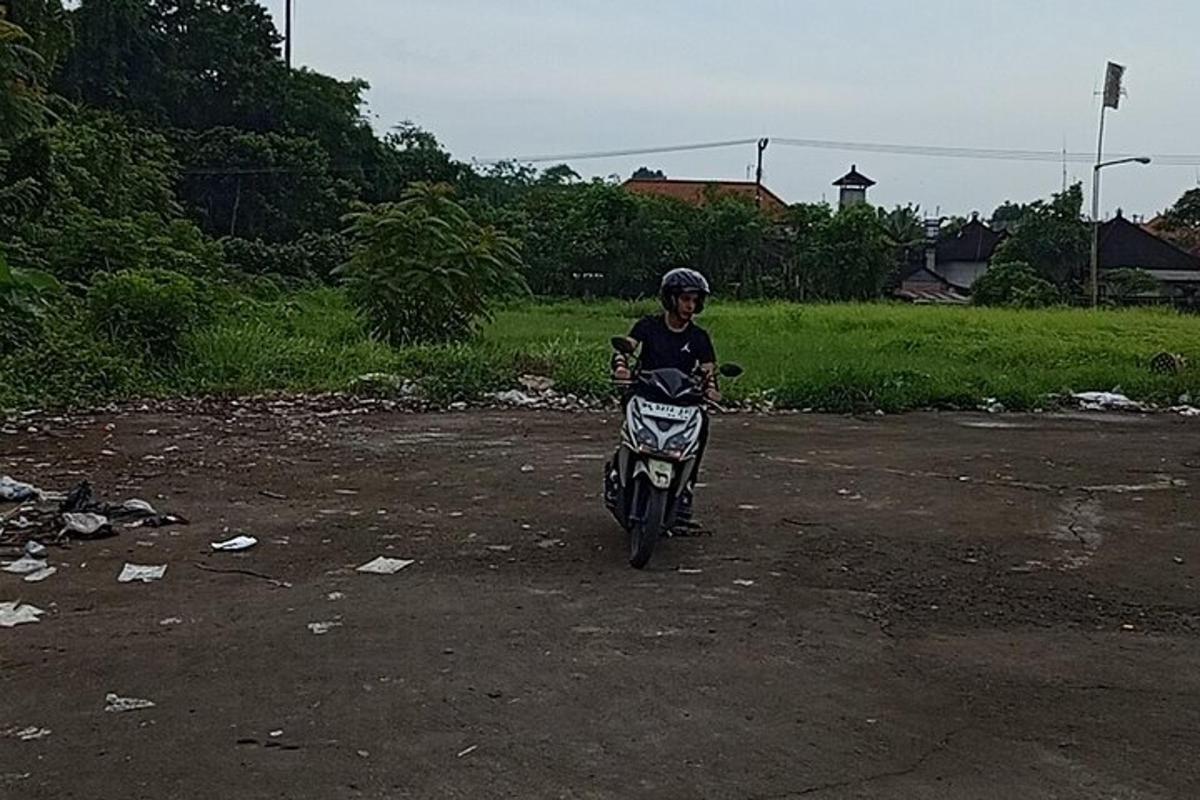 una persona che guida una motocicletta su una strada sterrata