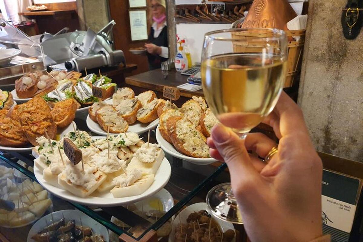 een persoon die een glas wijn vasthoudt voor een tafel met eten
