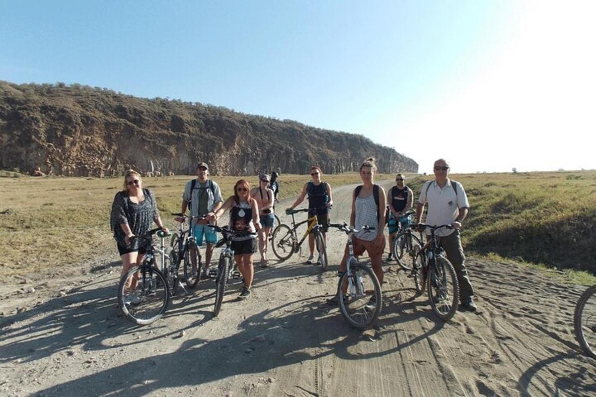 eine Gruppe von Menschen, die auf einer unbefestigten Straße Fahrrad fahren