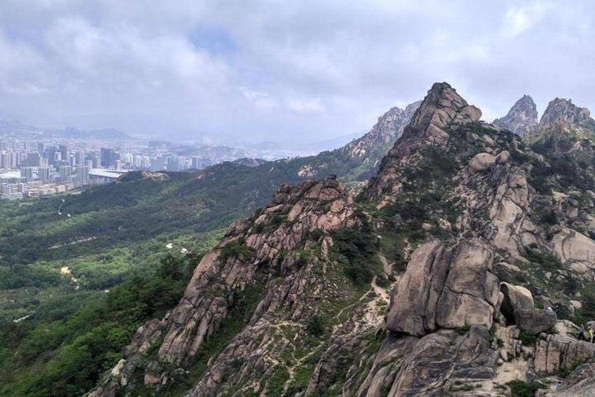 a rocky mountain with a city in the background