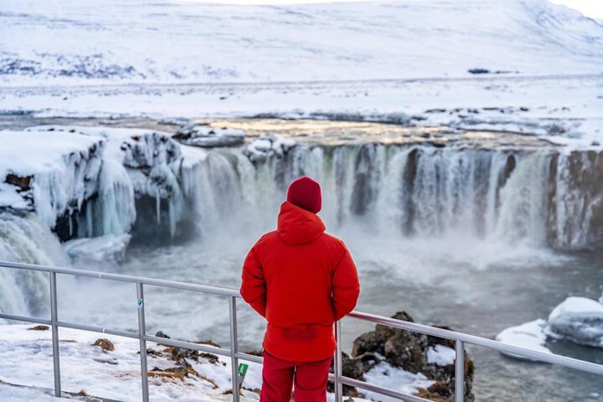 seseorang berjaket merah melihat air terjun