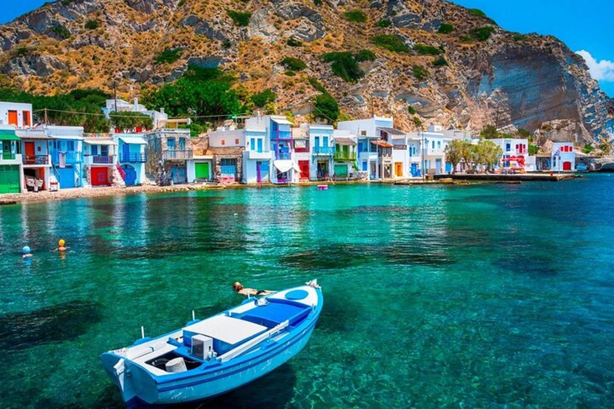 Un barco azul en el agua cerca de un grupo de casas.