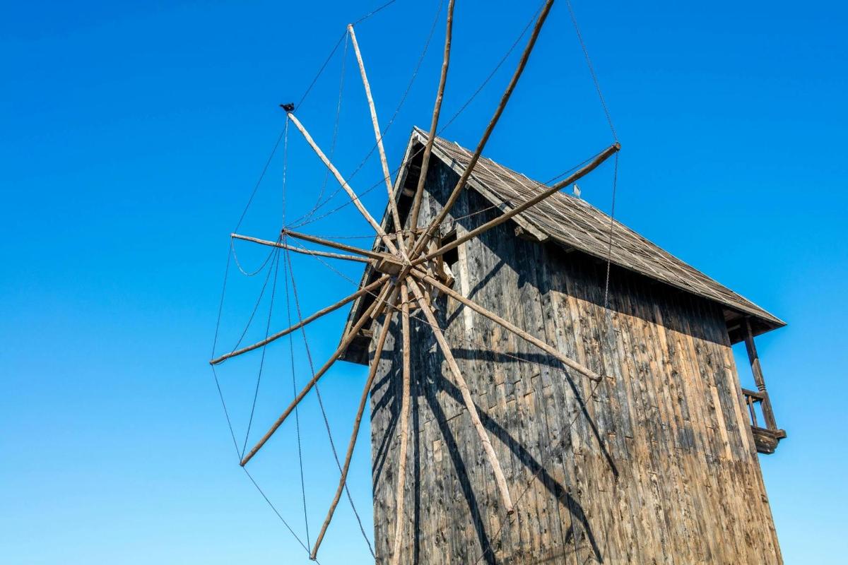 an old wooden windmill against a blue sky