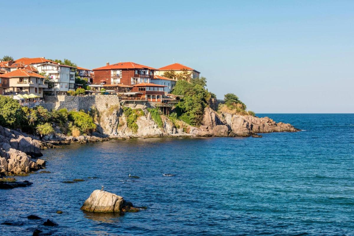 a group of houses on a hill next to the water