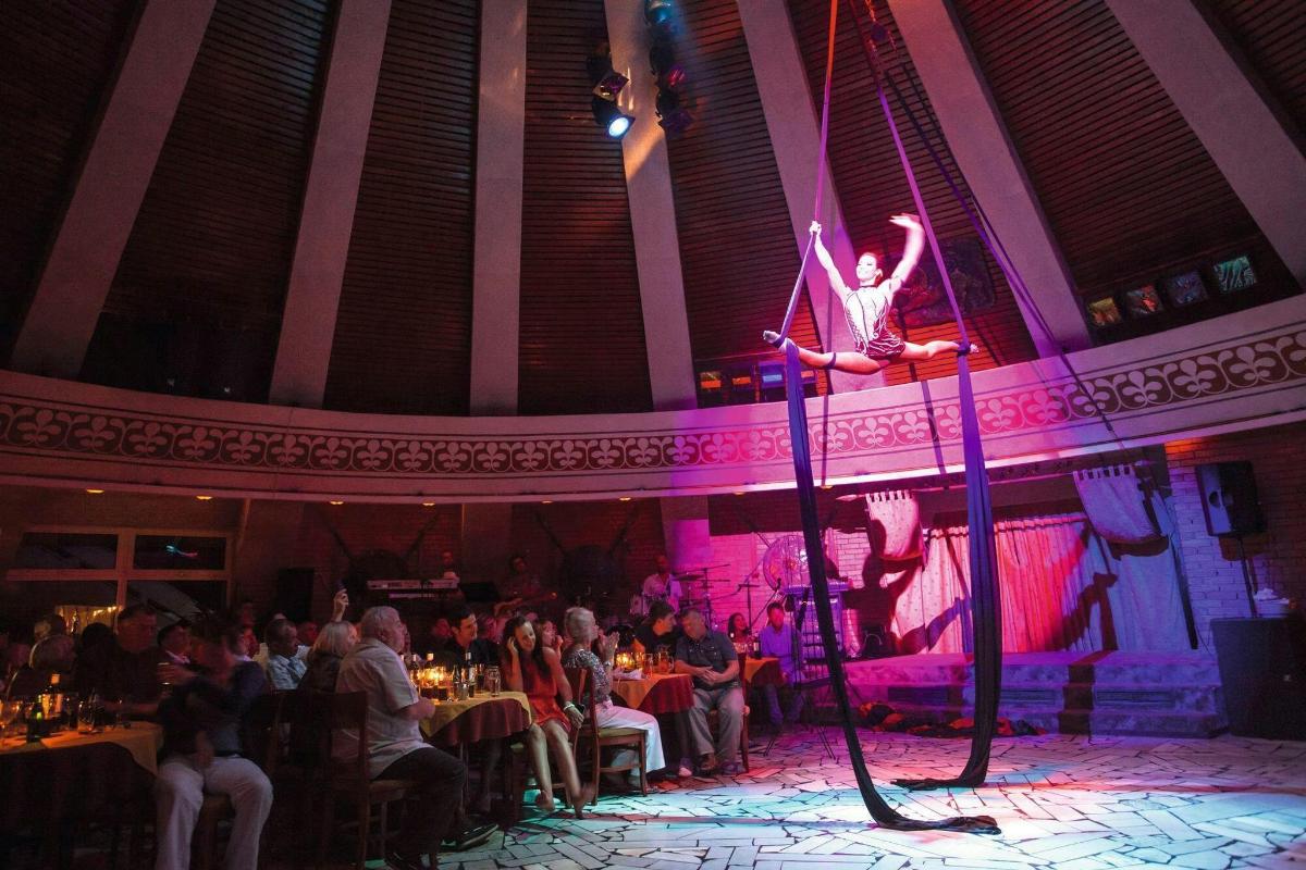 a performer on a pole on a stage in a restaurant