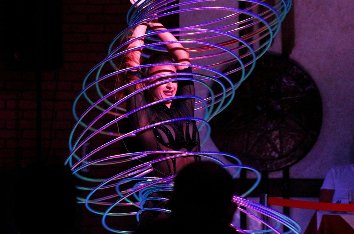 a sculpture of a woman is lit up with purple lights