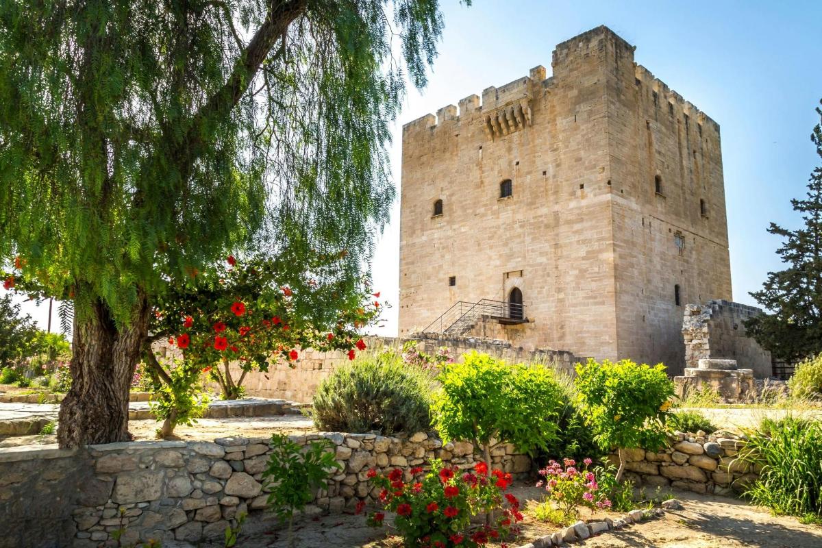 a large stone building with a tree and flowers