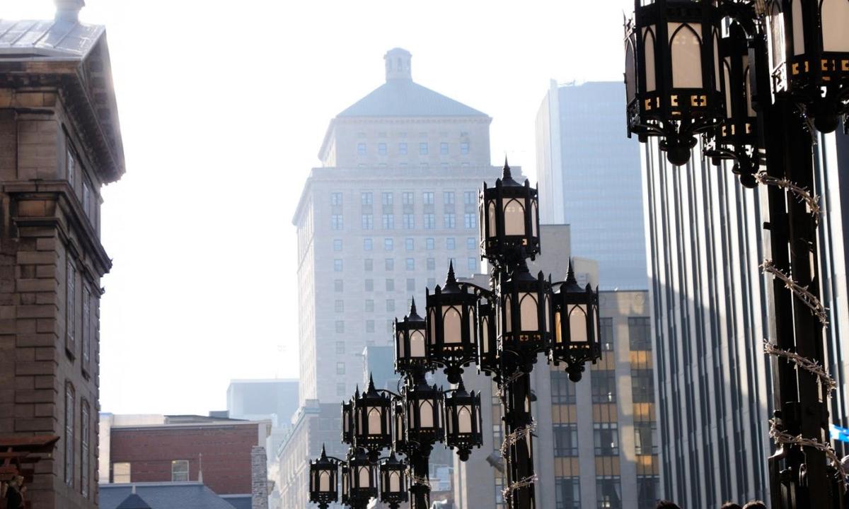 um grupo de postes de luz em uma cidade com prédios