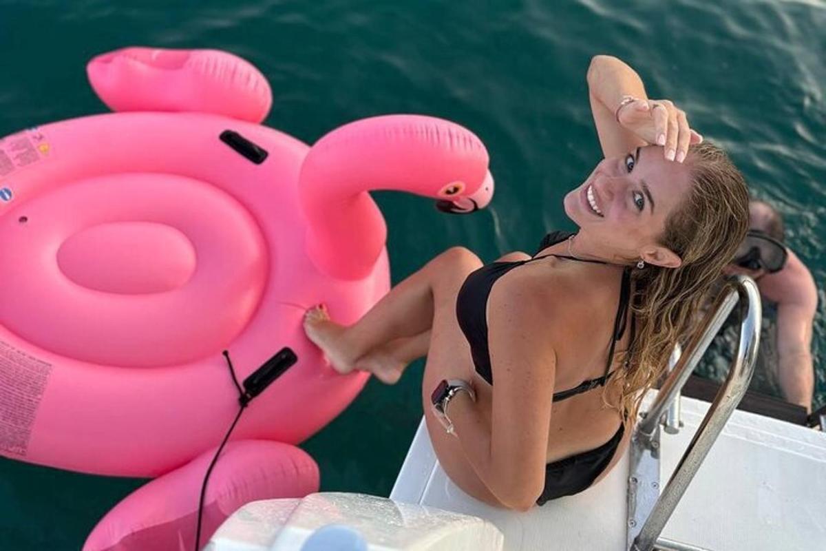 naine istub paadis, millel on roosa flamingo-ujuk