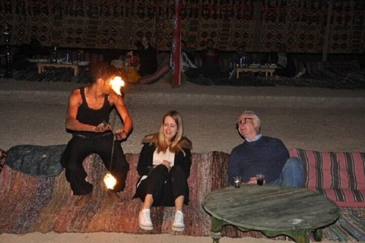 un uomo e una donna seduti su un divano con un fuoco acceso
