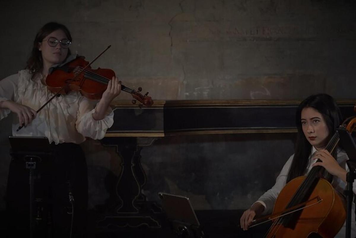 due donne che suonano il violino davanti a un pianoforte