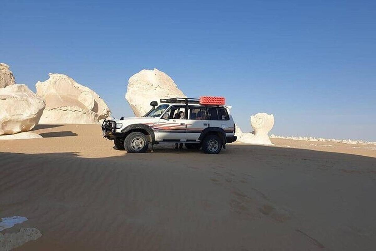 un camion bianco parcheggiato nella sabbia del deserto