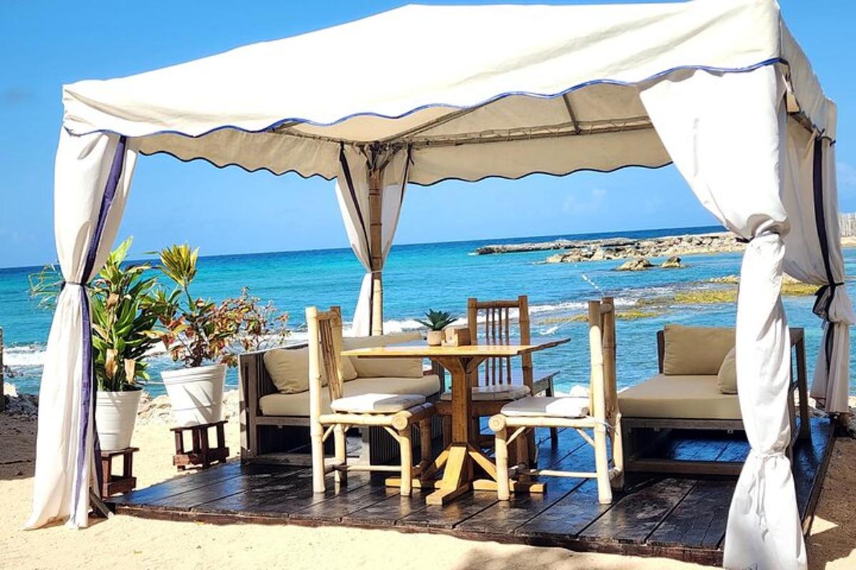 a gazebo on the beach with a table and chairs