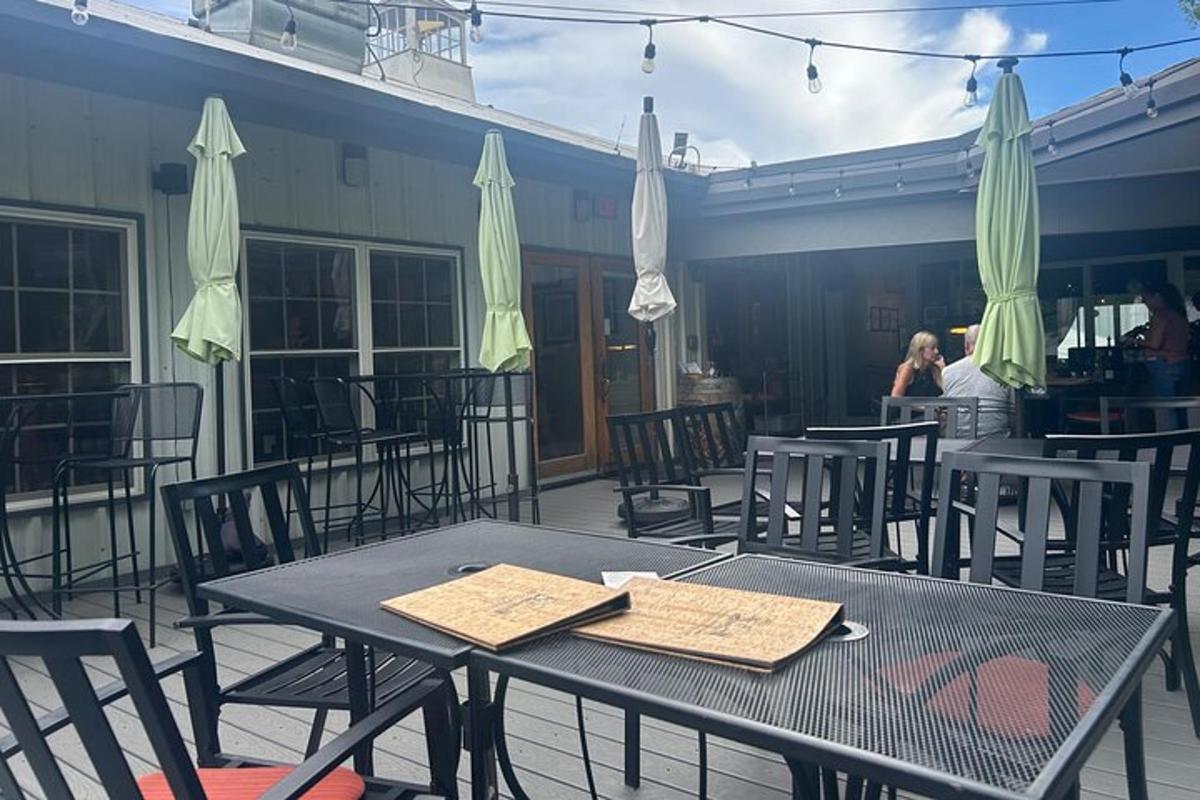 ein schwarzer Tisch mit Stühlen und Sonnenschirmen auf einer Terrasse