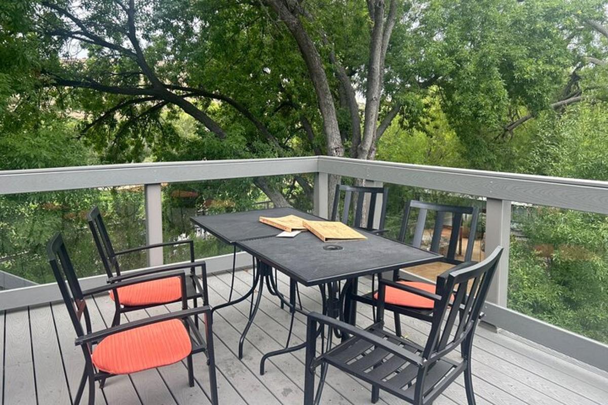 ein schwarzer Tisch und Stühle auf einer Terrasse mit Bäumen
