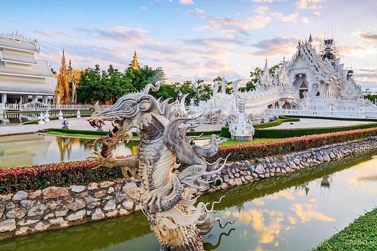 ein weißer Tempel mit einer Drachenstatue im Wasser