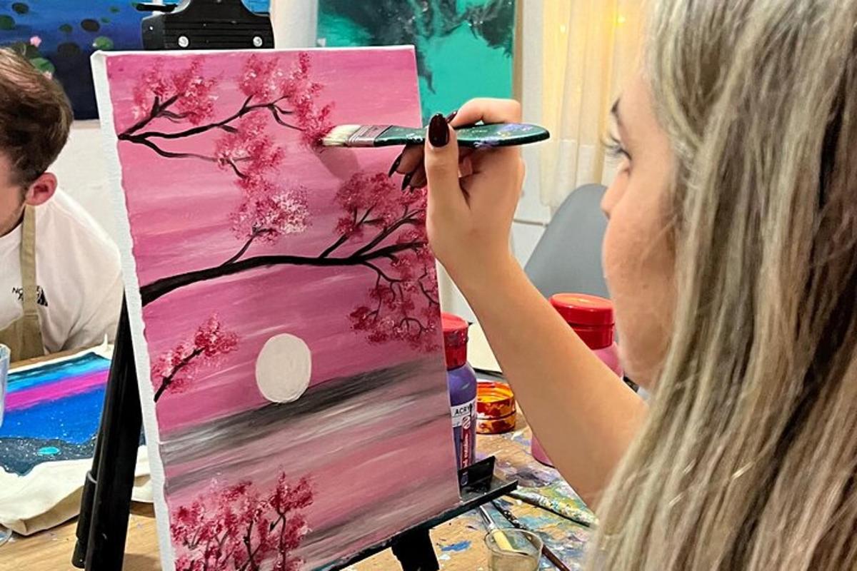 a woman painting a painting of a cherry tree