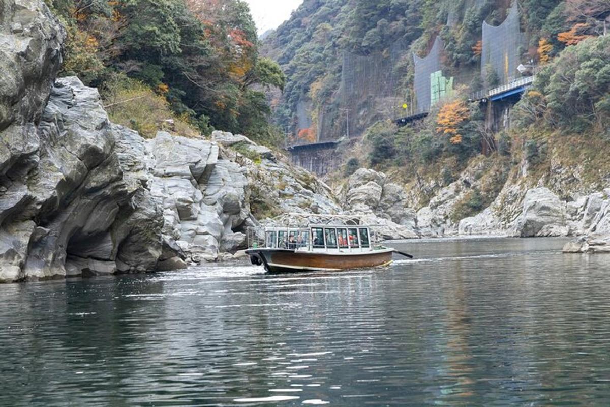 a boat on the water near a rocky mountain