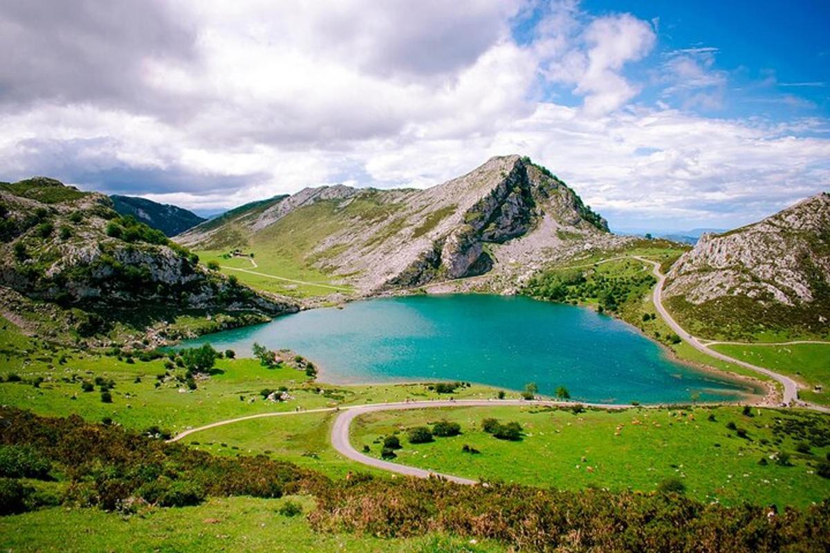 a lake in the middle of a field with mountains