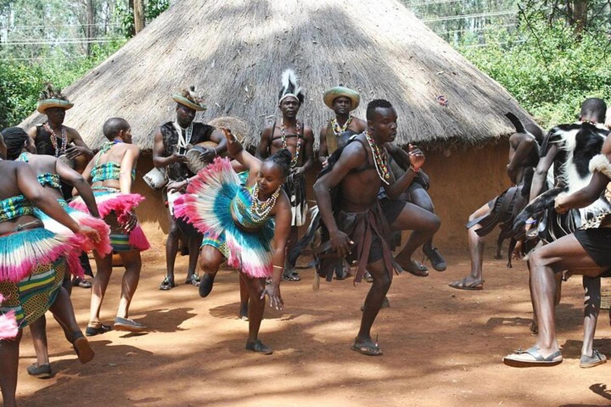 un groupe de personnes dansant devant une hutte