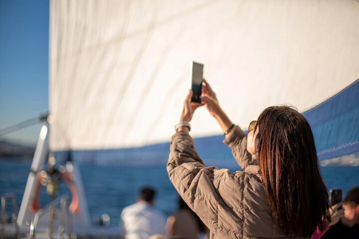 bir kadının cep telefonuyla bir teknenin fotoğrafını çekmesi