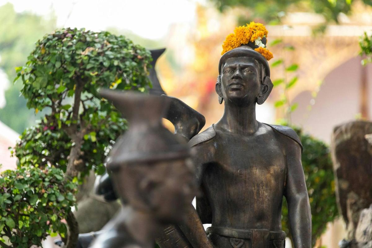 eine Statue einer Frau mit einer Blume auf dem Kopf