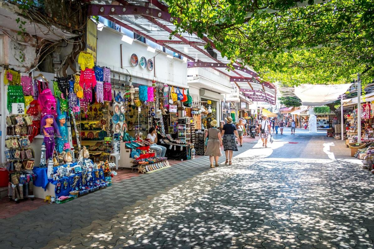 a group of people walking through a street with shops