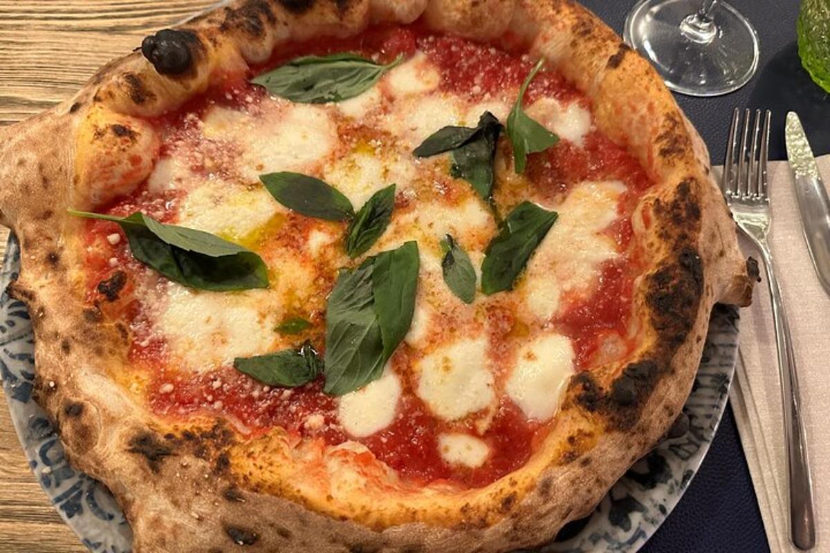 een pizza met basilicumblaadjes op een bord op tafel