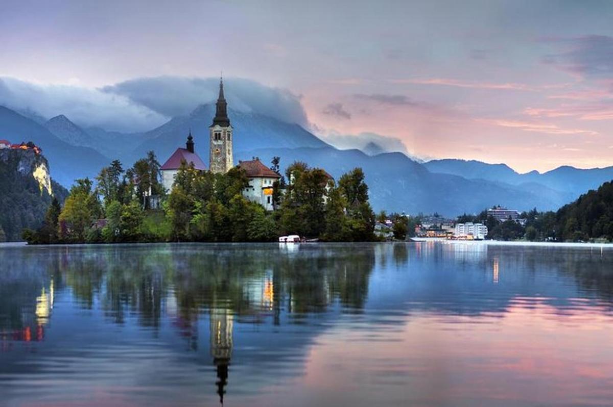 um grande lago com uma igreja e uma torre do relógio