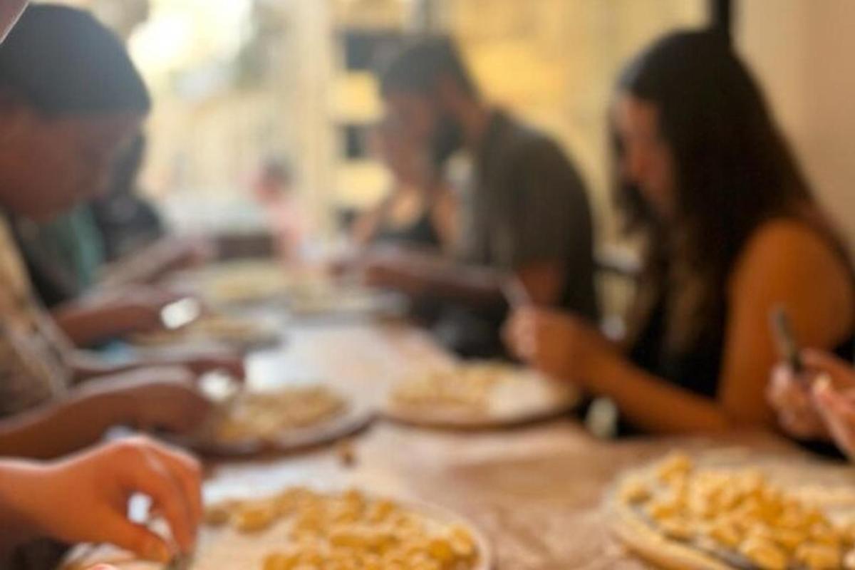 un grup de oameni așezați în jurul unei mese mâncând pizza