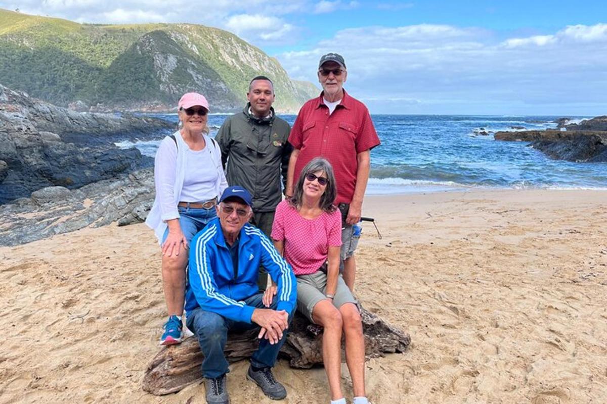 a group of people posing for a picture on the beach