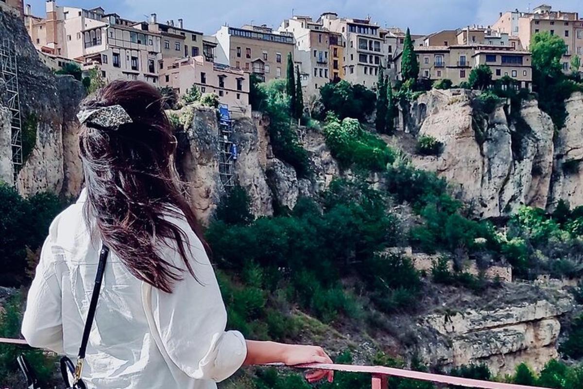 a woman standing on a balcony looking at a mountain