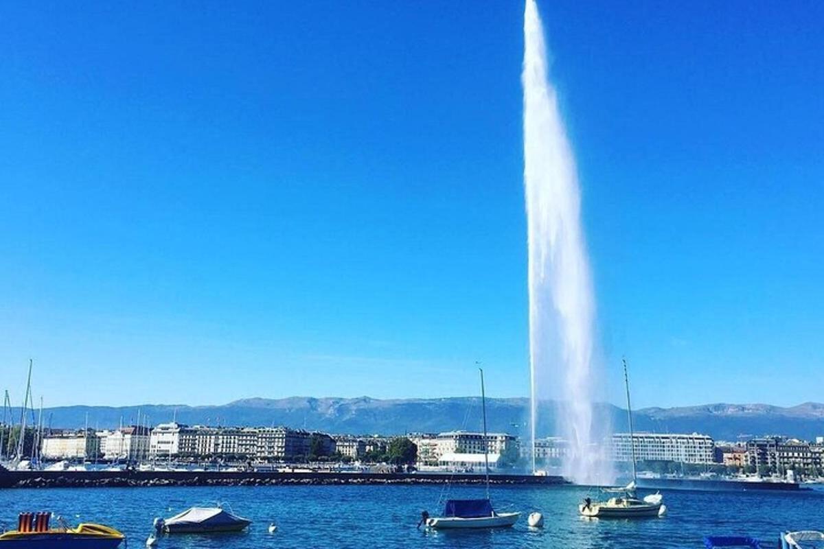 a fountain in the middle of a body of water with boats