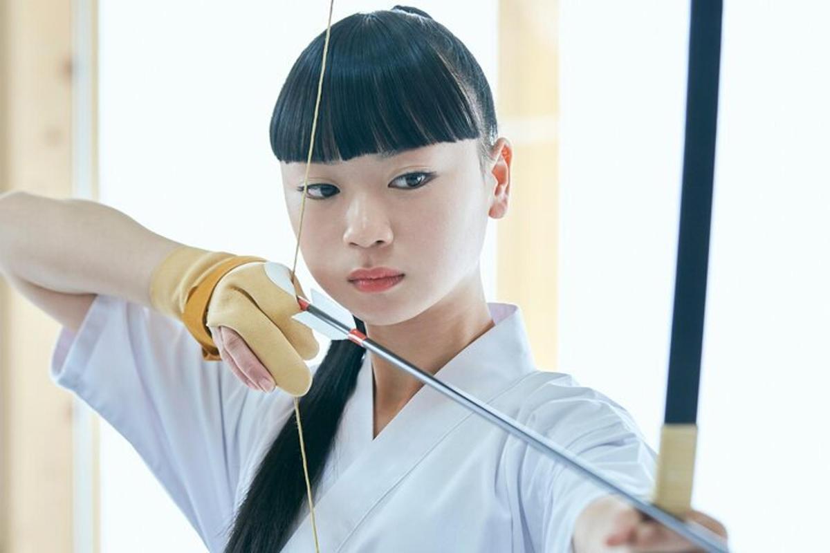a young woman holding a bow and arrow
