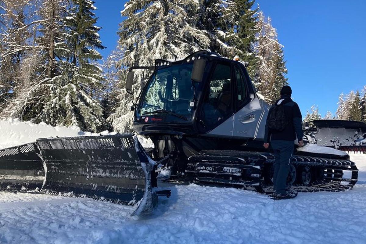 a man standing next to a bulldozer in the snow