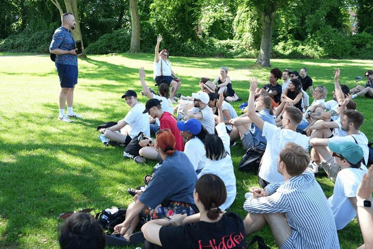 en gruppe mennesker som sitter på gresset i en park