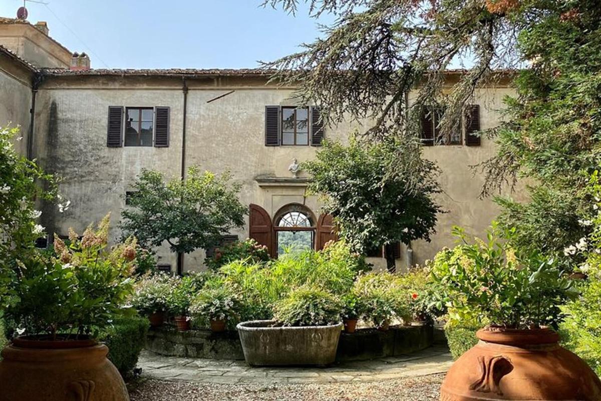 Una casa antigua con plantas en macetas en el frente.