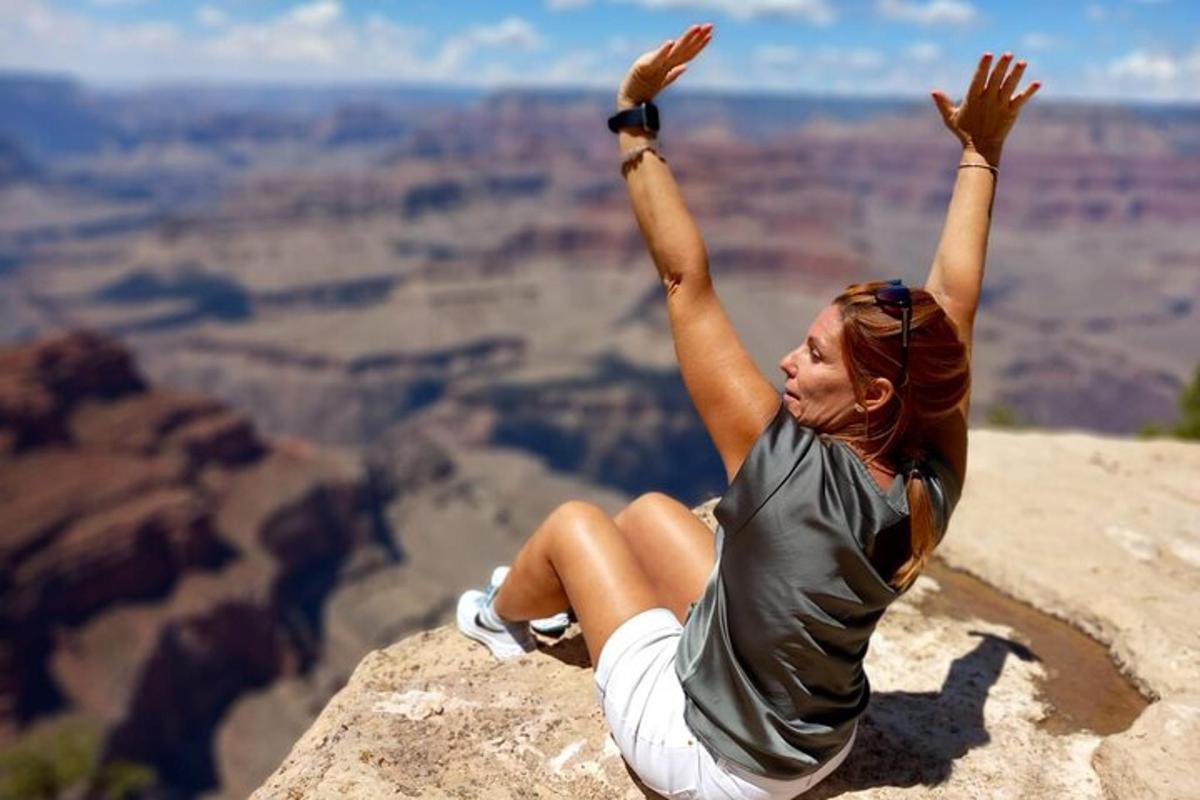 a woman laying on the edge of the grand canyon