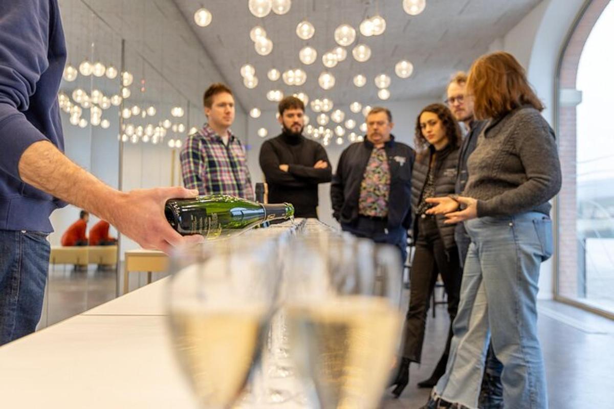 skupina lidí stojících kolem stolu s vinnými sklenicemi