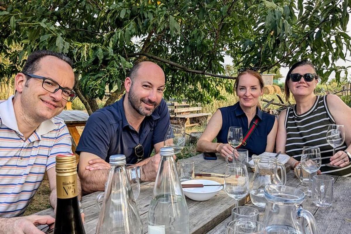 un grup de persones assegudes a una taula amb copes de vi
